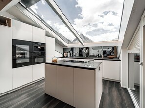 A modern kitchen with a skylight, built-in appliances, and a central island. - Kusi's Ranch Appartement/Fewo Dachwohnung by Interhome (Saas-Fee)