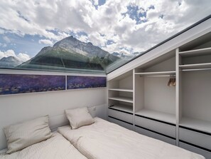 A bedroom with a bed, a wardrobe, and a view of mountains through a skylight. - Kusi's Ranch Appartement/Fewo Dachwohnung by Interhome (Saas-Fee)