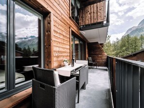A balcony with a table and chairs, overlooking a mountainous landscape. - Kusi's Ranch Studio Studio Nr. 11 Täschhorn by Interhome (Saas-Fee)