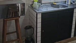 Eine Küche mit Mikrowelle, Kaffeemaschine und Spüle.