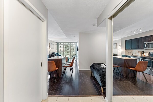 A modern apartment with a kitchen, dining area, and a living room with a sofa. - Altitude Residences (Toronto)