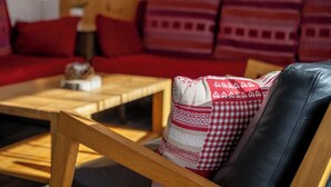 A cozy living room with a wooden coffee table, a red sofa, and patterned cushions. - Haus Azur Appartement/Fewo Wohnung Nr. 1 by Interhome (Saas-Almagell)