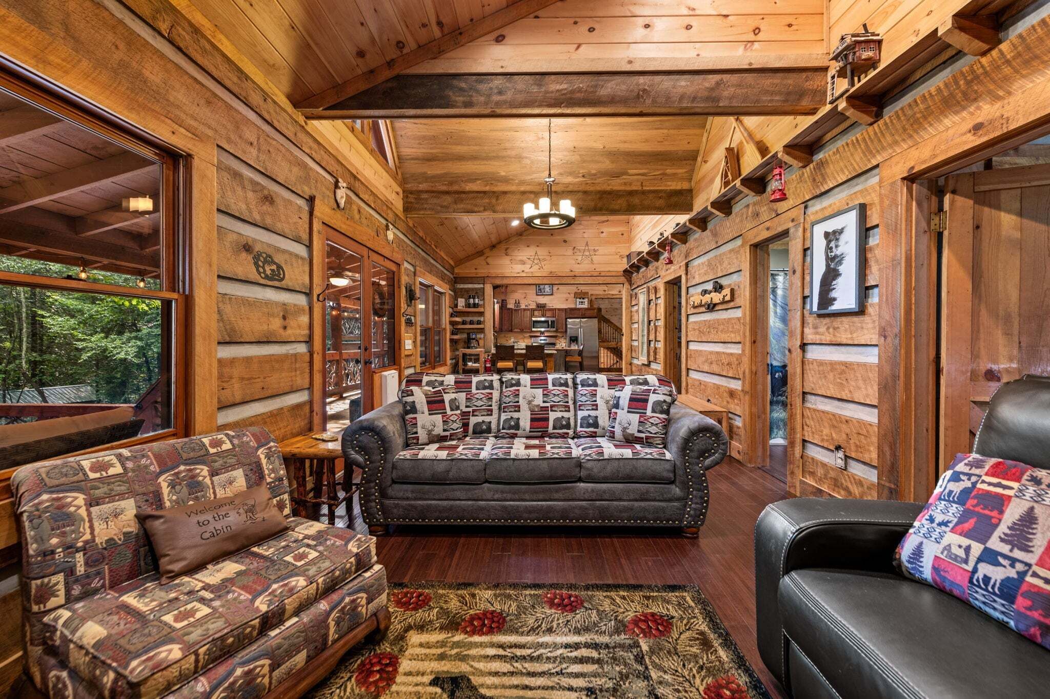A log cabin interior with a sofa, armchairs, and a dining area.