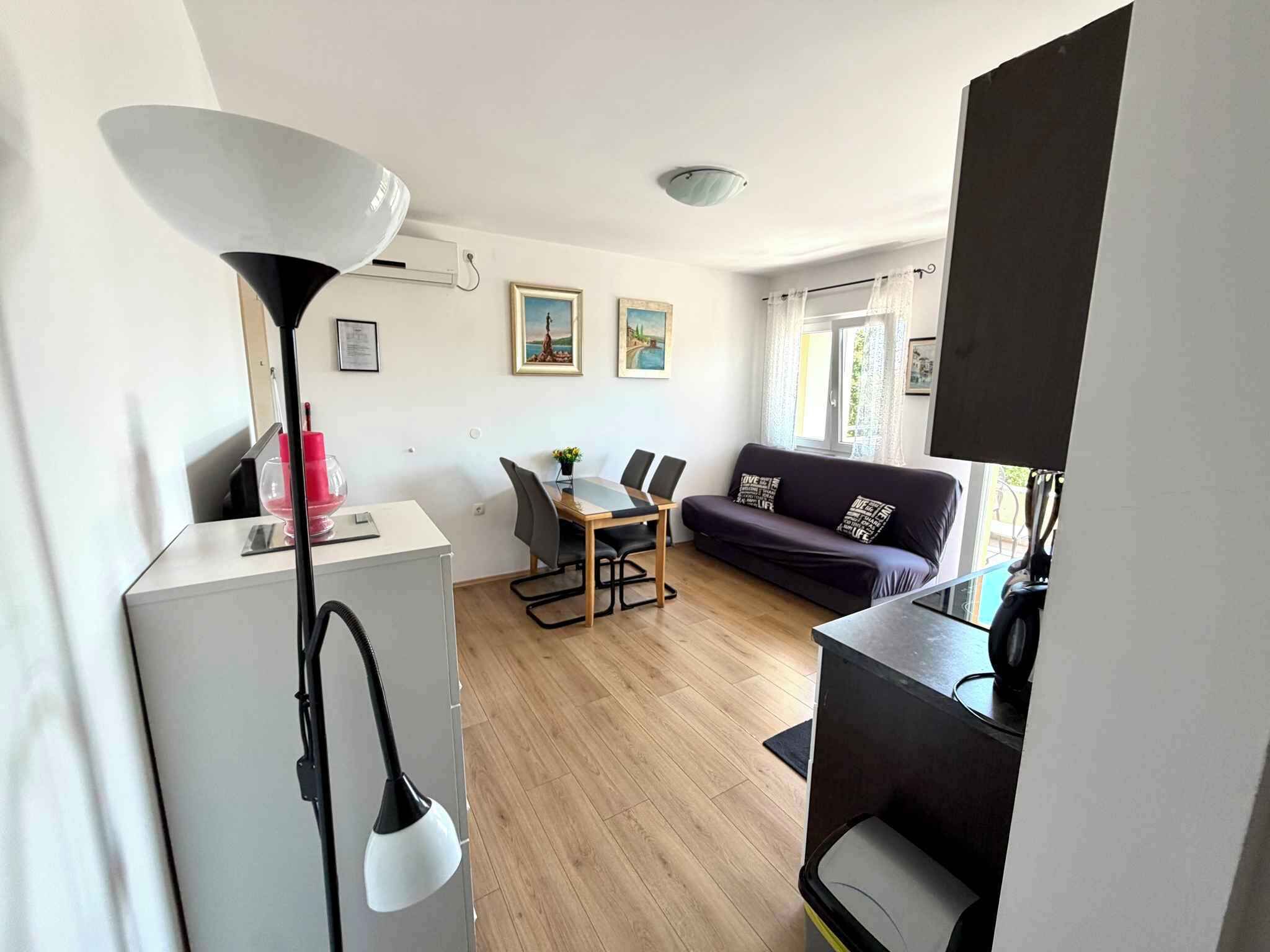 Un espace de vie compact comprenant un coin repas, un canapé et une lampe.