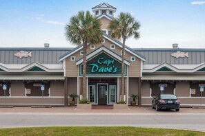 Ein Fischrestaurant namens 'Capt. Dave's' mit einer auffälligen Schautafel, einem Parkplatz und einem davor stehenden Auto.