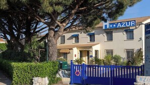 A building with a sign reading 'AZUR' and a blue gate. - Hotel Azur (Fos-sur-Mer)