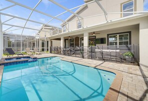 An indoor swimming pool with a glass ceiling, lounge chairs, and a seating area with a view of the pool. - 9 Bedroom Themed Villa Sleeps 24 with Private Pool Spa and Arcade (Kissimmee)