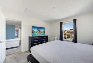 A bedroom with a bed, a dresser, a painting, and a window with curtains. - Champions Legacy 8BR Pool Villa (Kissimmee)