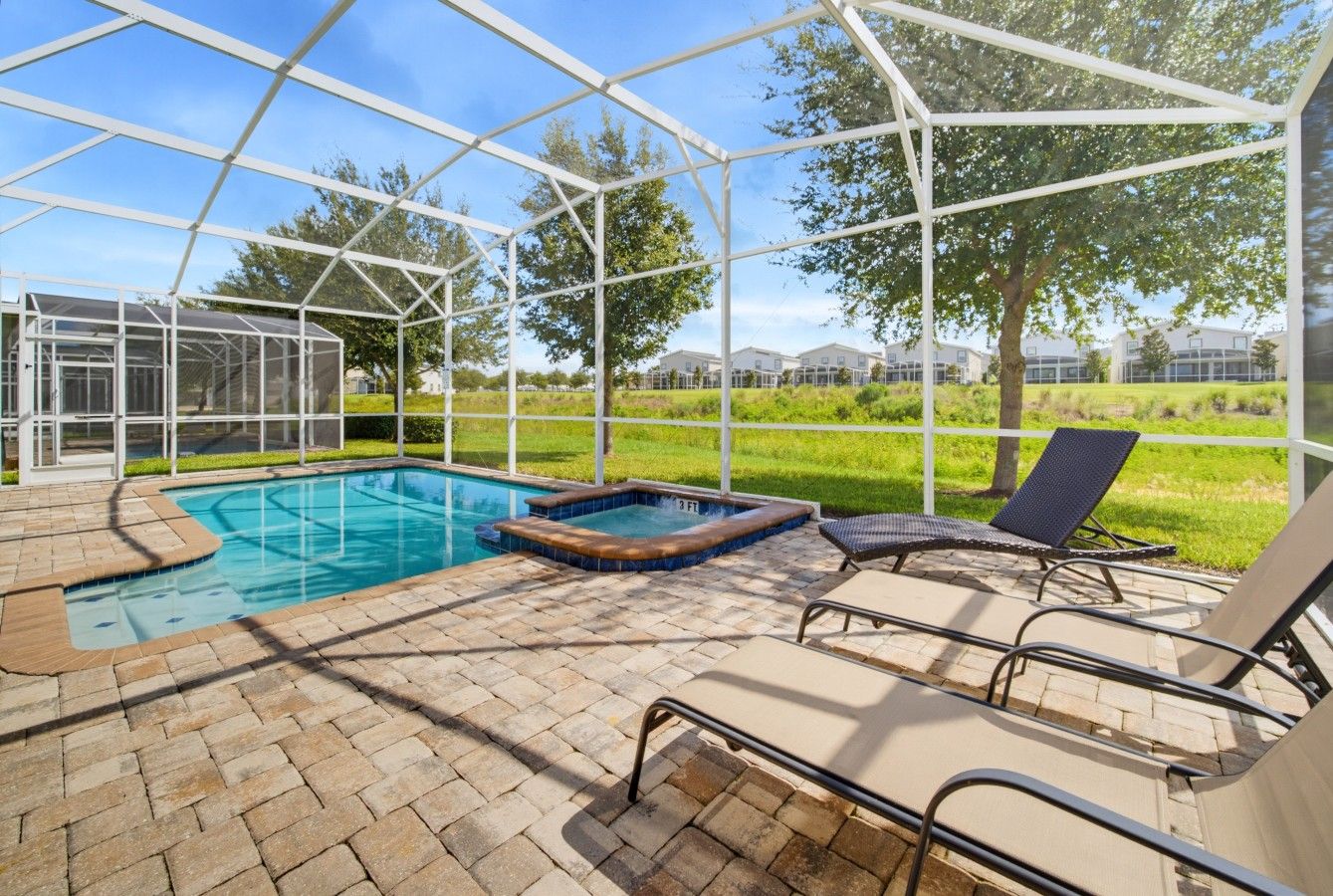 Una piscina al aire libre techada con sillones de descanso y un jacuzzi.