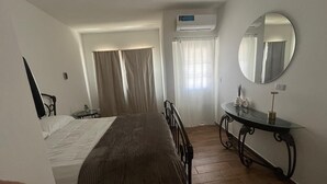 A bedroom with a bed, a bedside table, a mirror, and an air conditioning unit. - 🏙️ EXECUTIVE APARTMENT FOR RENT | 2 BEDROOMS | CENTRAL LOCATION (Chihuahua)