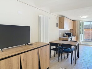 Eine moderne Küche mit Holzausstattung, einer integrierten Mikrowelle und einem Essbereich mit Holztisch und Stühlen.