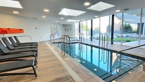 A swimming pool with sunroofed windows, lounge chairs, and a view of the outdoors. - Rbk Amplio Dpto Familiar con linda vista (Concón)