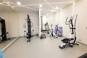 A gym with various exercise equipment, a mirror, and a water dispenser. - Rbk Amplio Dpto Familiar con linda vista (Concón)