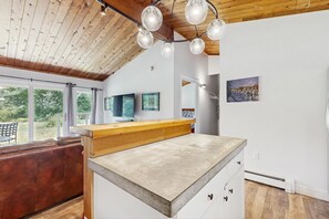 Una cocina moderna con encimera de madera, un banco y vistas al exterior.