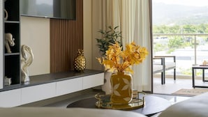 A hotel room with a TV, a plant, a pineapple, and a view of the outdoors. - The Vue Paradisiac Private Beach Pool Gated (St. Ann's Bay)