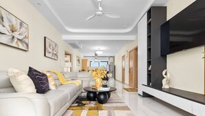 A modern living room with a sofa, coffee table, and artwork on the walls. - The Vue Paradisiac Private Beach Pool Gated (St. Ann's Bay)