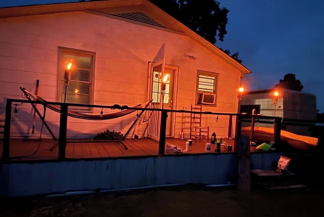 A house with a porch, a hammock, and a ladder.