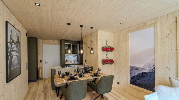 En matplats med ett träbord, stolar och en stor målning som föreställer ett berglandskap.
