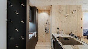 A modern kitchen with a wooden interior, a marble countertop, and a view of a snowy landscape.
