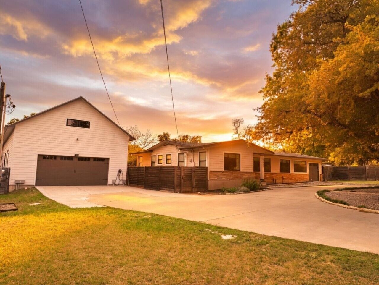 A residential property with a garage, a covered porch, and a well-maintained lawn.