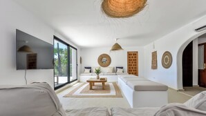 Un salon moderne avec un canapé, une table basse et un téléviseur fixé au mur.