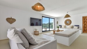 Un salon moderne avec un canapé, une table basse et un téléviseur.