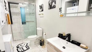 Ein Badezimmer mit Waschbecken, Spiegel und Duschbereich.