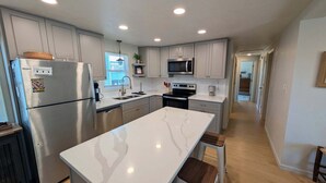 A modern kitchen with stainless steel appliances, white cabinetry, and a marble countertop. - The Hatch: New to the Program, Close to the Beach, Pet-Friendly (Avon)