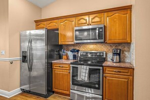 A kitchen with a stainless steel refrigerator, microwave, stove, and oven. - Walk to Beach · Hot Tub, Fire Pit & Game Room · Sleeps 10, Dogs Welcome (Seminole)