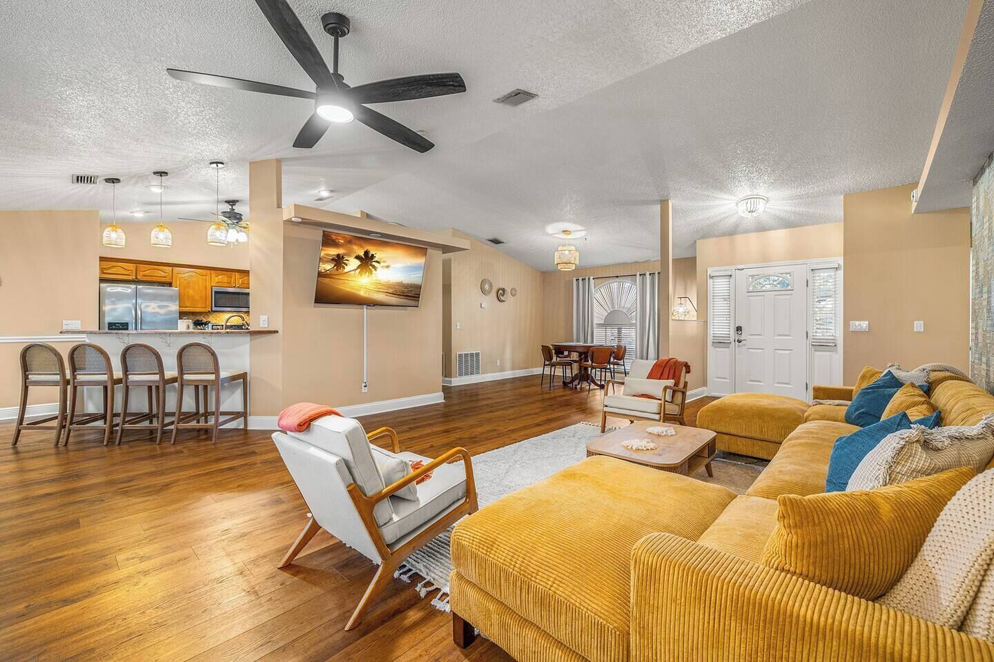 A spacious living area with a kitchen, dining area, and a large sofa.