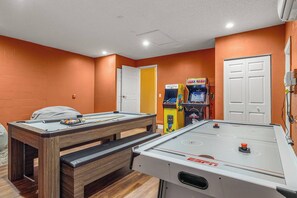 Ein Raum mit Billardtisch, Kicker und zwei Spielautomaten.