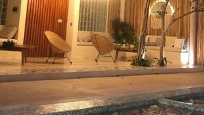 A modern house with a pool, outdoor seating, and a well-lit entrance. - Carmela  (Tulum)