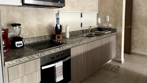 A modern kitchen with a microwave, blender, coffee maker, and dishwasher. - Carmela  (Tulum)