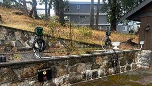 Een stenen muur met een 'RESERVED' bord en een 'CASA' logo, een fietsenstalling en een gebouw op de achtergrond.