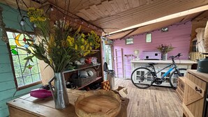 Um interior rústico com vigas de madeira, uma bicicleta e um baú de madeira.