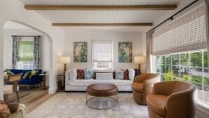A living room with a sofa, armchairs, a coffee table, and a view through large windows. - Bella Azul - Charming Home Minutes from Campus (Eugene)