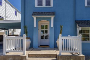 A two-story building with a blue exterior, a white front door, and a small porch with white railings. - Bella Azul - Charming Home Minutes from Campus (Eugene)