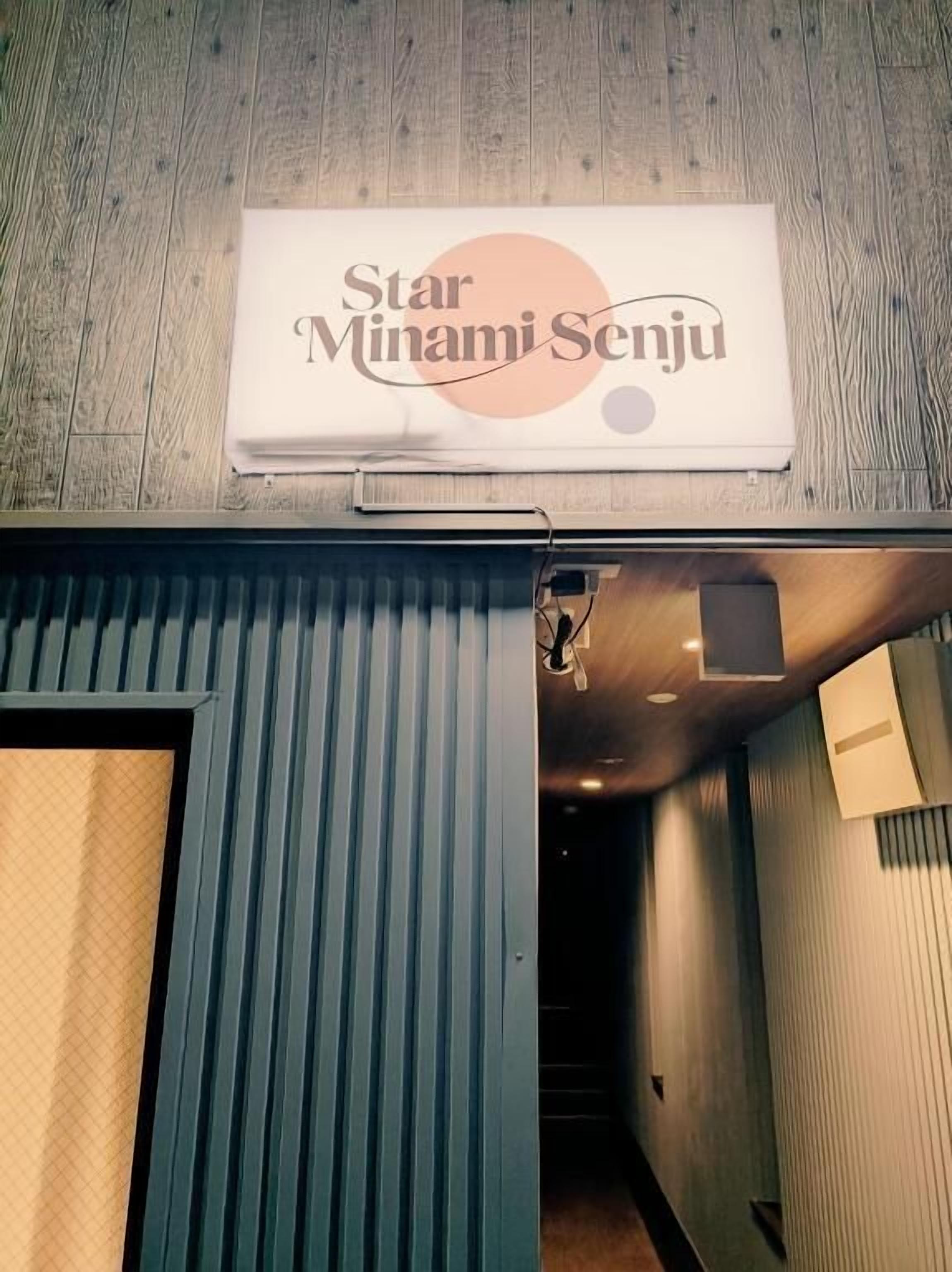 A hallway with a sign reading 'Star Minami Senju' and a door leading to a room.