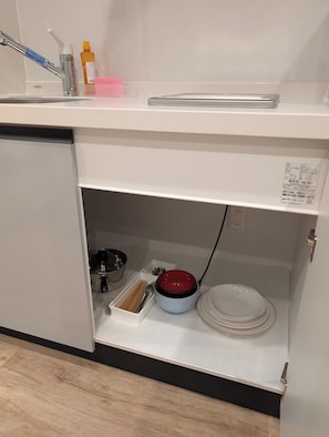 A kitchen with a sink, a dish rack, a red bowl, and a white plate. - Star Minami-Senju (Taito-ku)