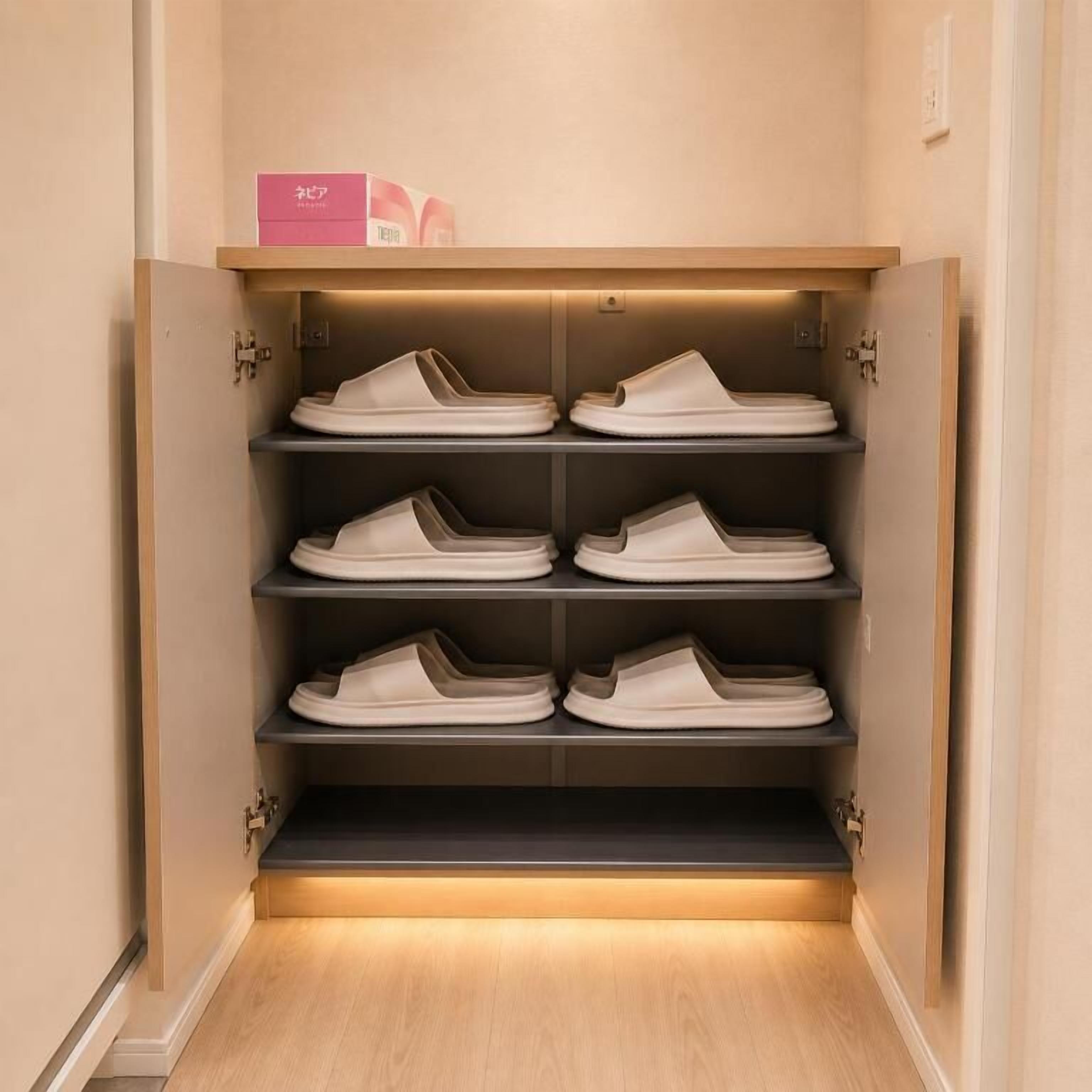 A shoe storage unit with multiple shelves and a pink box on top.