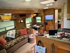 Een gezellig RV-interieur met een bank, een eettafeltje, een televisie en een kitchenette.