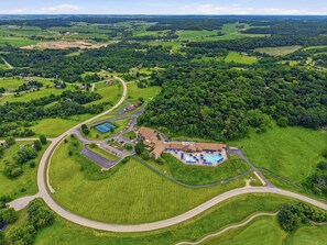 Ilmakuva lomakeskuksesta, jossa on uima-allas, tenniskentät ja golfkenttä.