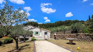 A stone house with a tiled roof, a gravel driveway, and a stone wall. - 3 bedroom pet friendly home in Tauriers (Tauriers)