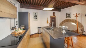 A kitchen with a central island, a stone oven, and a rustic wooden ceiling. - Cozy home in Pelussin with WiFi (Pelussin)