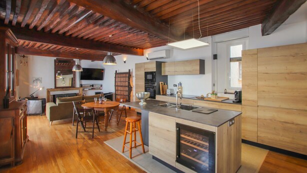 A spacious kitchen with a central island, wooden flooring, and a rustic ceiling. - Cozy home in Pelussin with WiFi (Pelussin)
