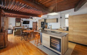 A spacious kitchen with a central island, wooden flooring, and a rustic ceiling. - Cozy home in Pelussin with WiFi (Pelussin)