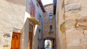 A narrow street with stone buildings, a wooden door, and a small window. - Cozy home in Pelussin with WiFi (Pelussin)