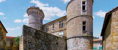 A historic stone building with two prominent towers and a central courtyard.