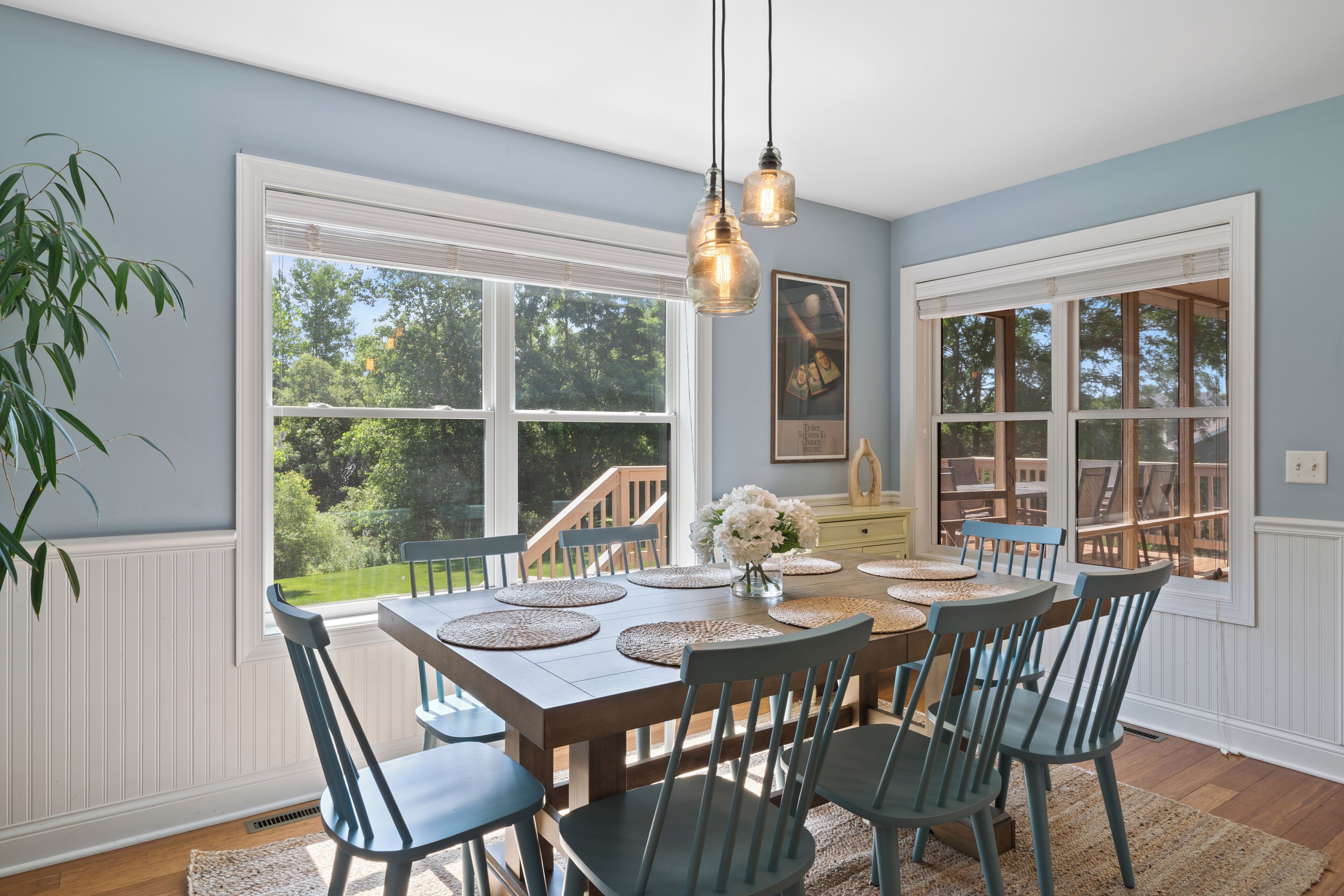 A dining area with a wooden table, chairs, and a view of the outdoors.