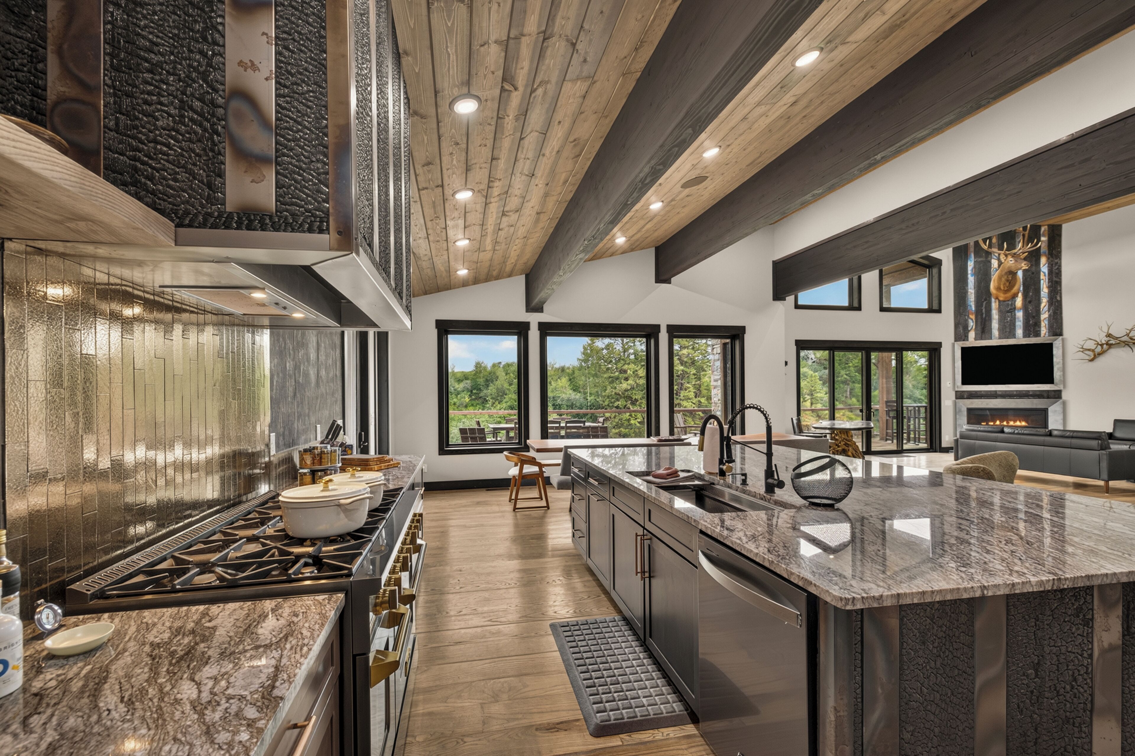 Une cuisine moderne dotée d’un grand îlot central, d’une cuisinière intégrée et d’une grande fenêtre donnant sur l’extérieur.